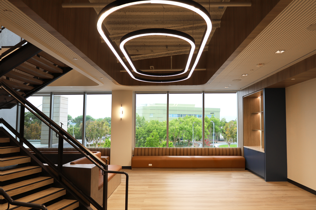 Office lobby with layered halo LED ceiling fixtures and staircase